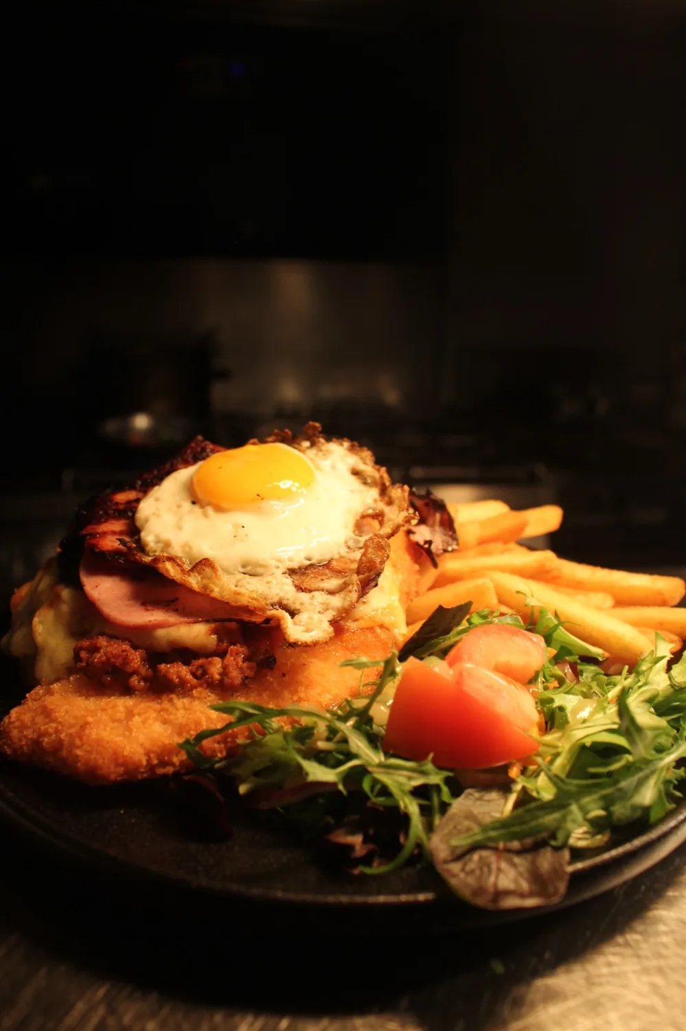 A chicken parmigiana with chips and salad.