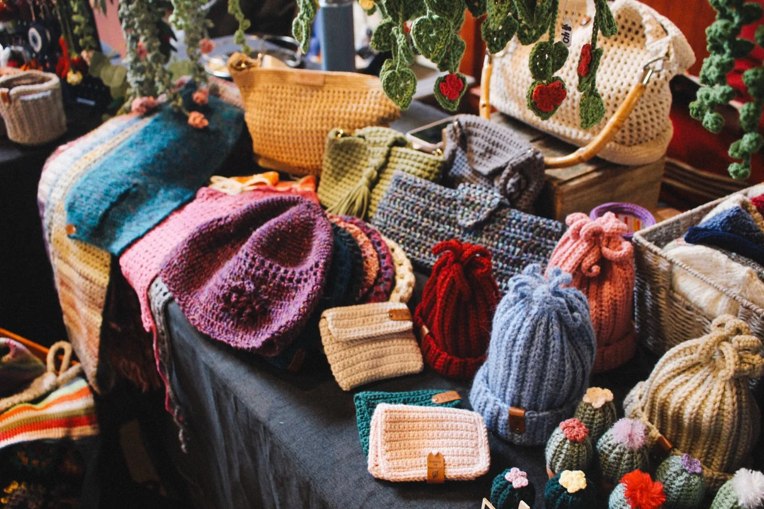 A stall of hand-crocheted bags and hats in bright colours.