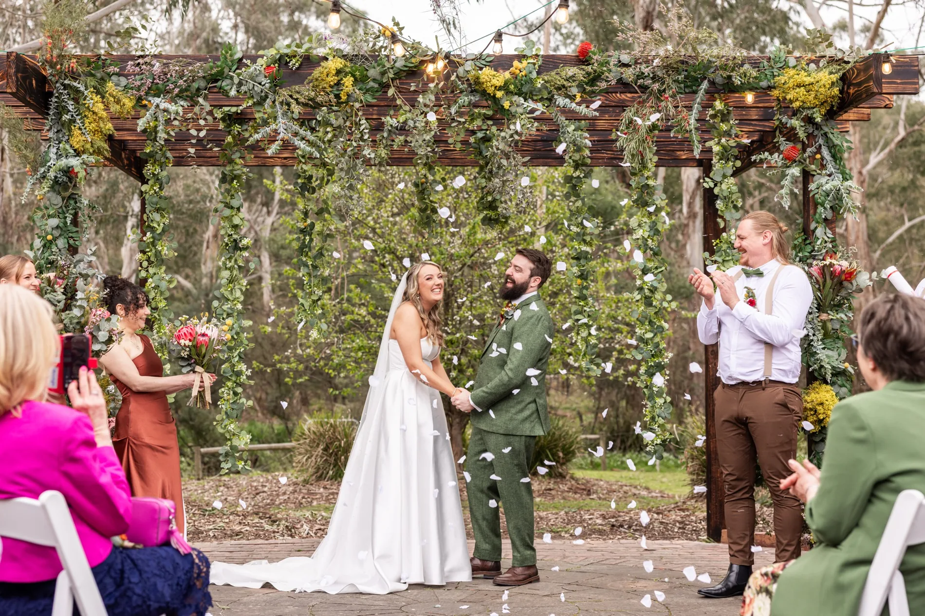 Confetti thrown over a couple under the pergola after their ceremony.
